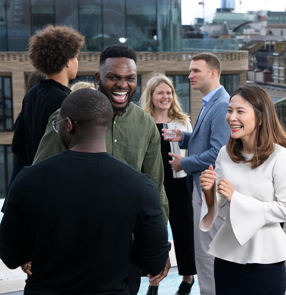 Group shot of people laughing whilst on a rood top 