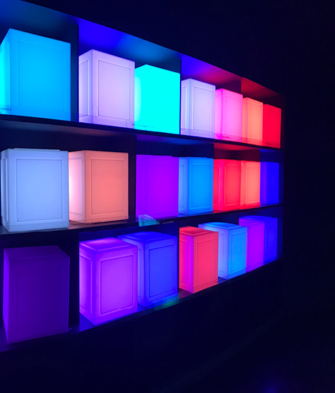 multicoloured cubes stored on a shelf in a dark room